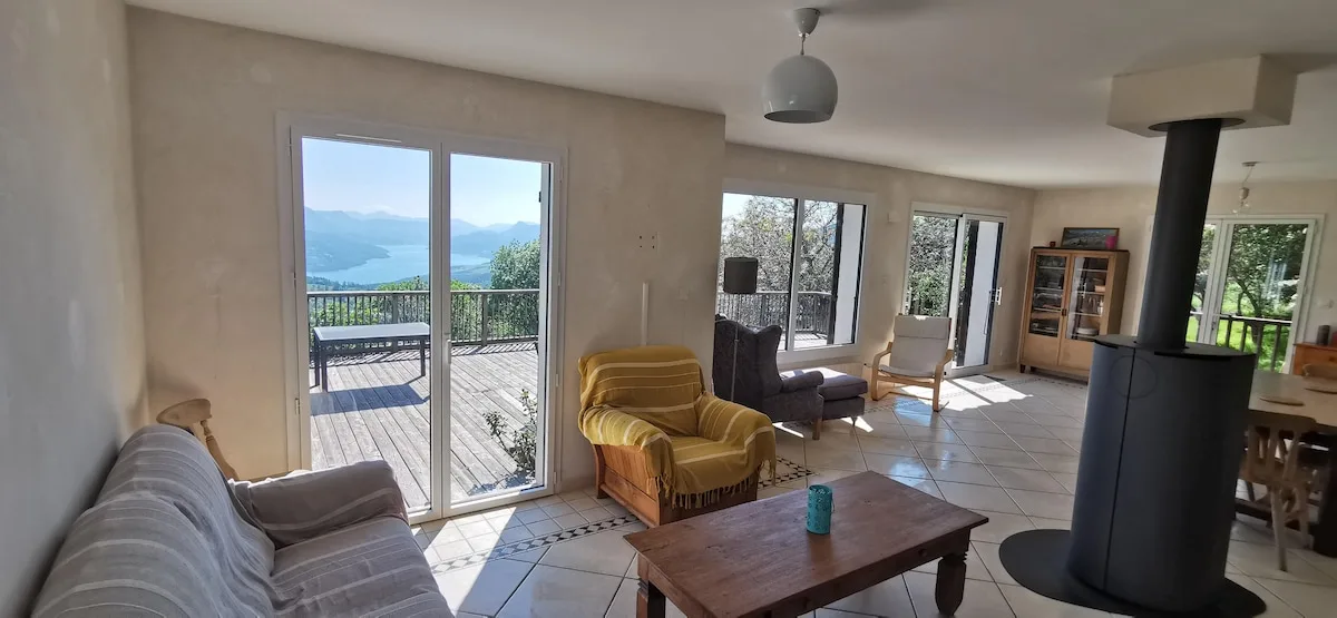 Salon lumineux avec poêle à bois et vue sur le lac